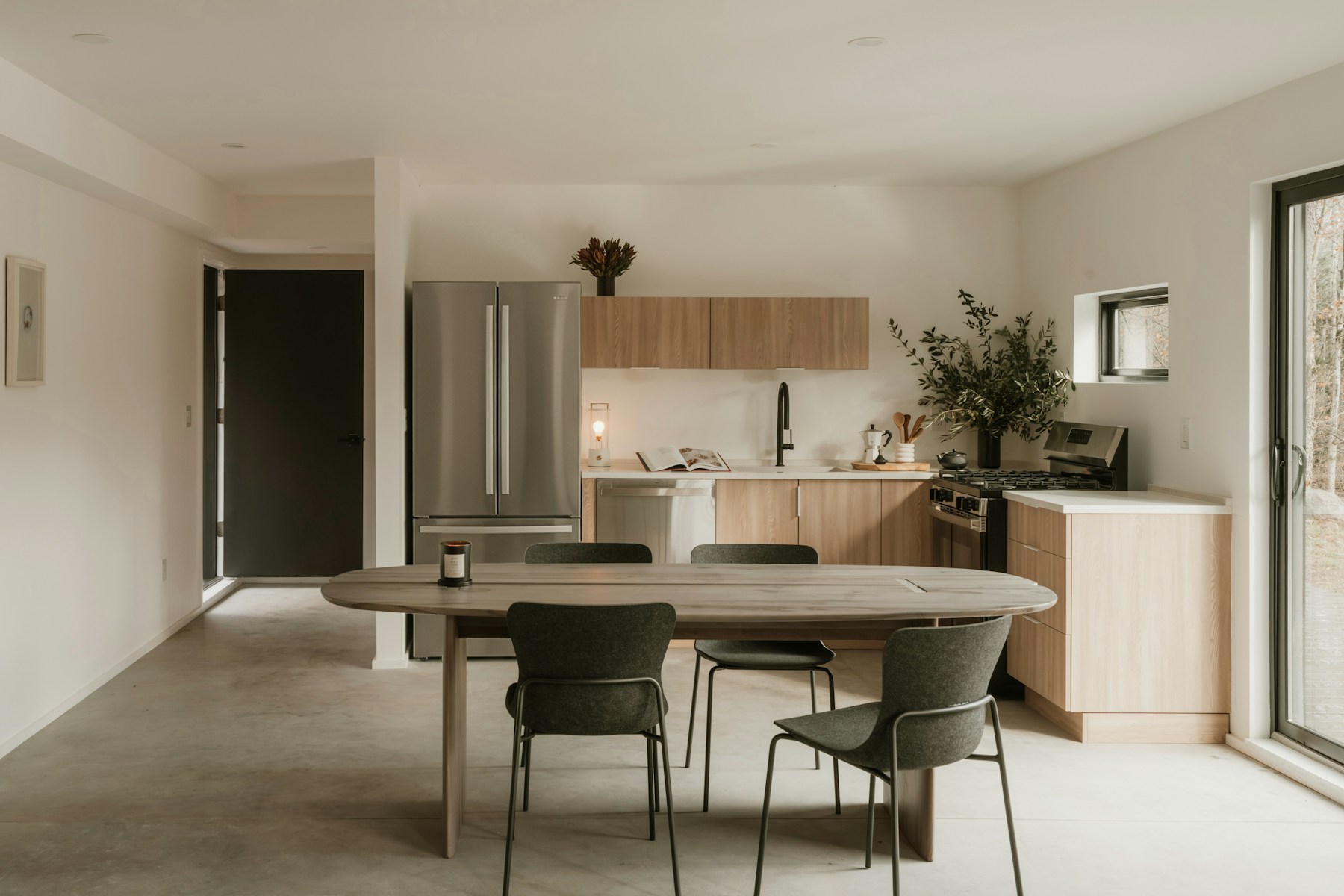 Minimal kitchen and dining area with light wood cabinetry